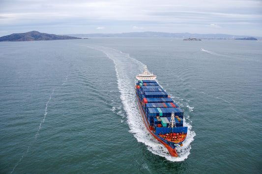 Aerial view of a large container ship sailing through open ocean waters
