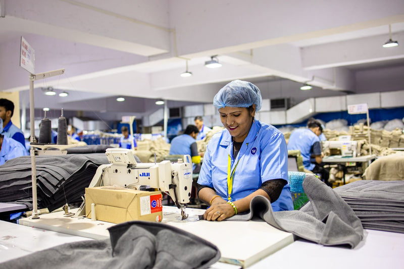 Busy textile factory with workers at sewing machines