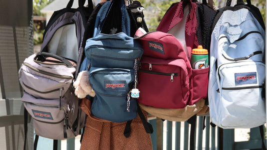 Colorful backpacks hanging on hooks outdoors, ready for a back-to-school retail display