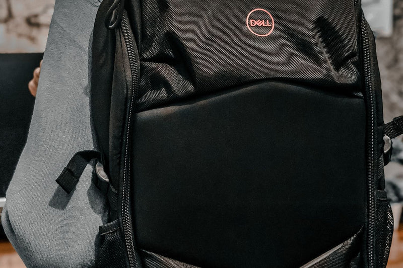 Close-up of a man wearing a black backpack showing fit and strap detail
