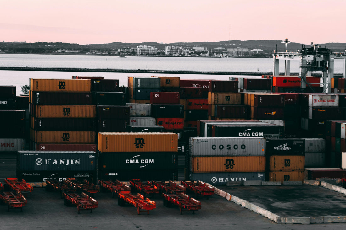 Freight containers stacked at port, illustrating Incoterms for bag importers
