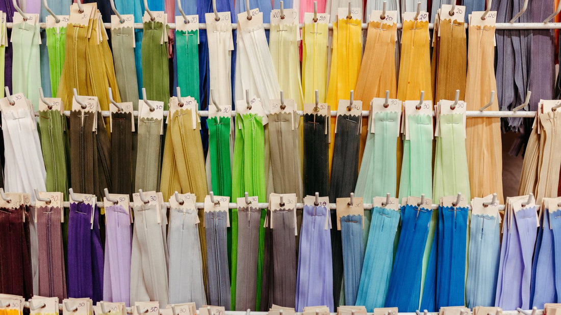 Colorful zippers hanging on display hooks in a workshop