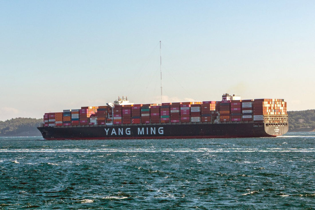 Cargo ship loaded with shipping containers sailing on a sunny day
