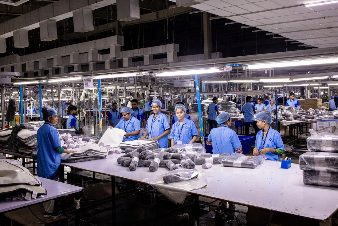 Textile factory workers packaging finished backpack orders on an assembly line