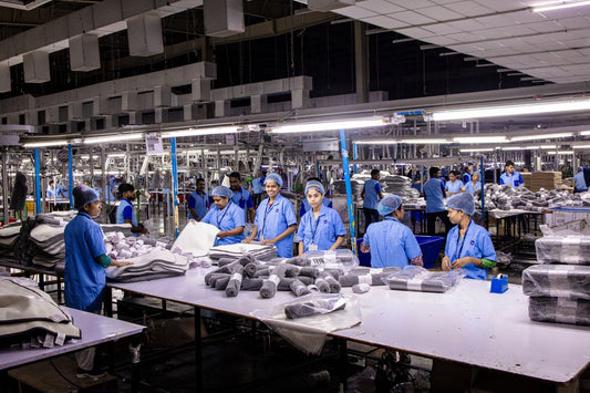 Textile factory workers packaging finished backpack orders on an assembly line