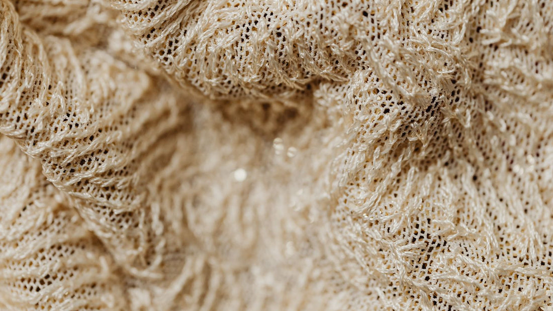 Close-up of beige woven fabric showing weave structure and fibers
