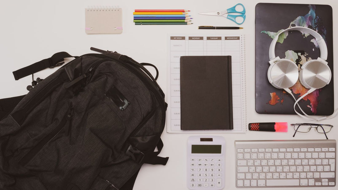 Overhead shot of a backpack near a calculator on an office desk
