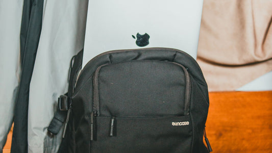 Person placing a laptop into a black backpack