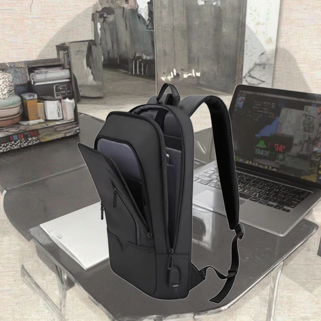 Autonoe slim business laptop backpack in black beside a laptop