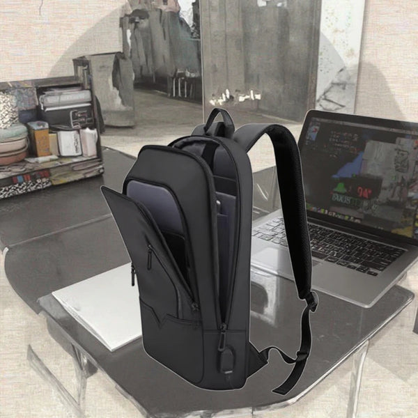 Autonoe slim business laptop backpack in black beside a laptop